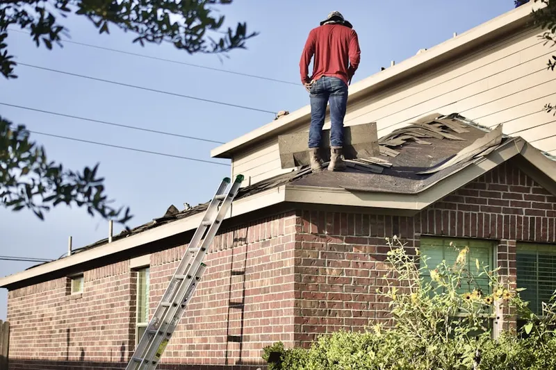 Professional roofer working on a residential roof in Glen Head
